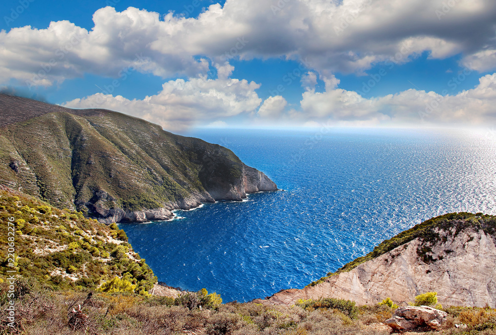 Beautiful view of the coast of Navagio on the Greek island of Zakynthos. The sea is clear blue and the sky blue with white clouds. Beautiful view of the coast of Navagio on the Greek island of Zakynthos. The sea is clear blue and the sky blue with white clouds.