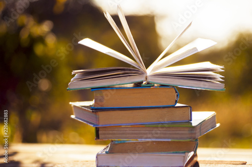 Open book on wooden table on natural background. Soft focus