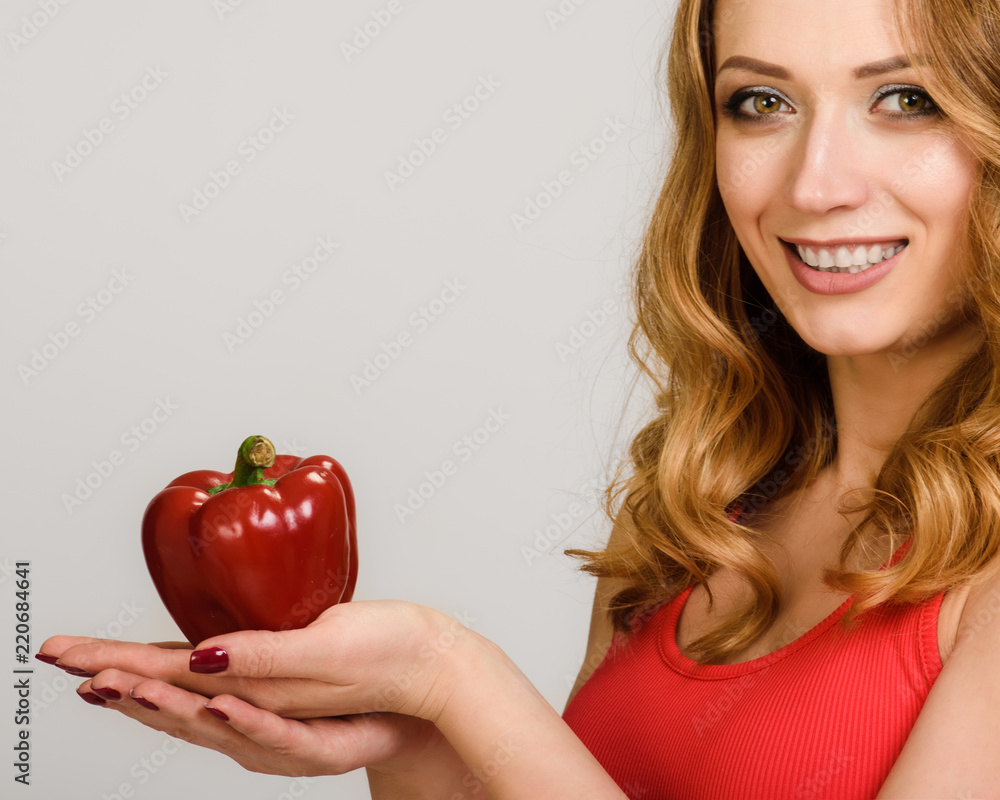 Young vegan woman holding red pepper in her hands Young vegan woman holding red pepper in her hands