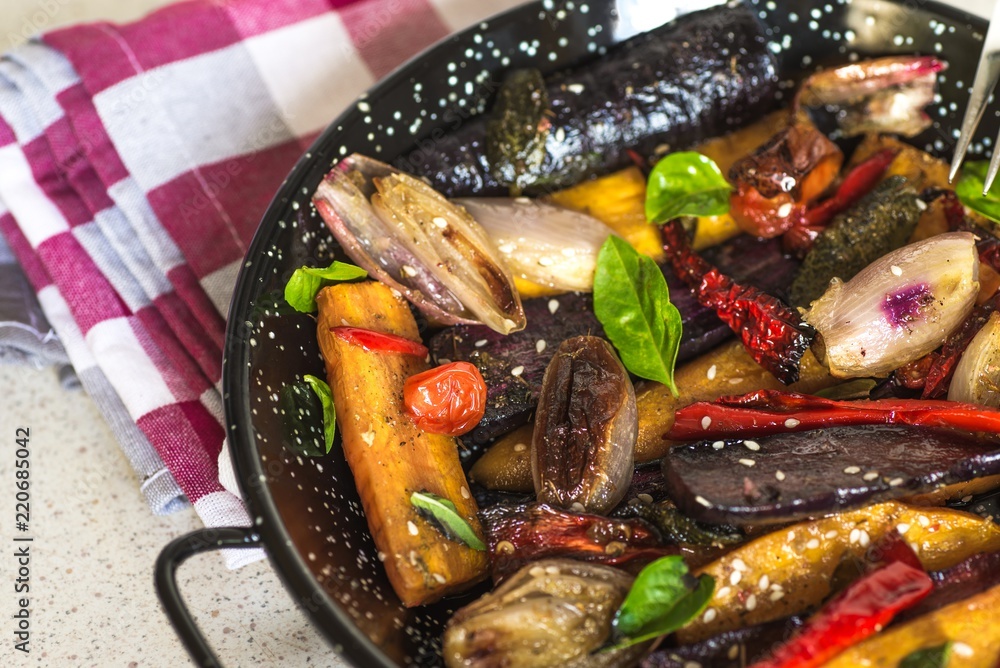 Baked vegetable on black pan with towel.