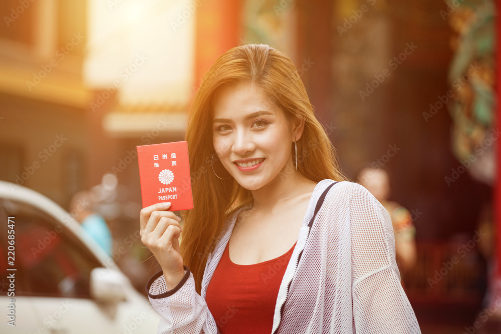 beautiful Young Asian women tourist traveler with backpack smiling and show passport of Japan in China town market culture beautiful Young Asian women tourist traveler with backpack smiling and show passport of Japan in China town market culture