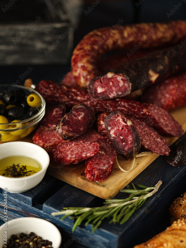 Salami sliced in rustic style. Salami sausage. Different sausages with cheese, grapes and olive