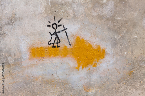 Symbol of the Way of Saint James, or Camino de Santiago, with a yellow arrow and a pilgrim on it