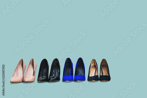 Set of high heels isolated on a pastel blue background. Different colors of shoes, high heels arranged in a row. The concept of buying new shoes, lifestyle of a woman.
