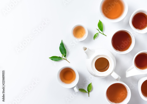 Tea concept,Teapot and cup of herbal tea with green tea leaves,top view