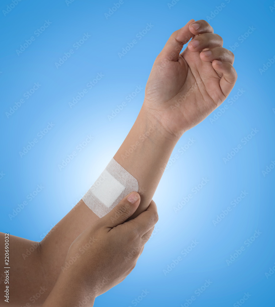 Plaster closed wound on the arm against blue background,Medical and healthcare concept. Plaster closed wound on the arm against blue background,Medical and healthcare concept.