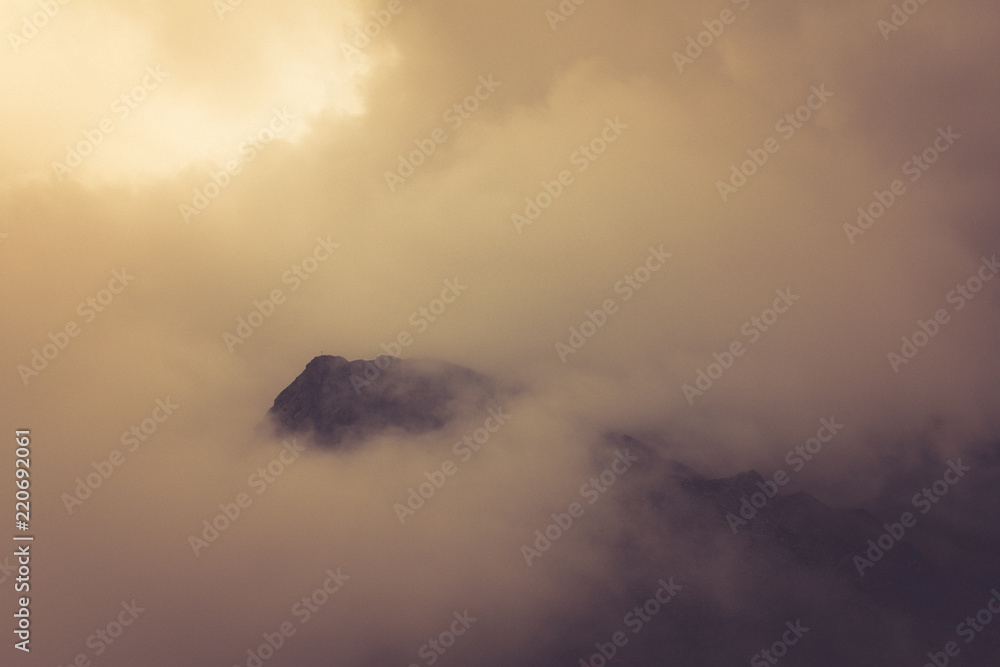 View of morning fog in the mountains. Misty landscape of rocky mountain slopes. Color toning and low contrast. Outdoor travel background. View of morning fog in the mountains. Misty landscape of rocky mountain slopes. Color toning and low contrast. Outdoor travel background.