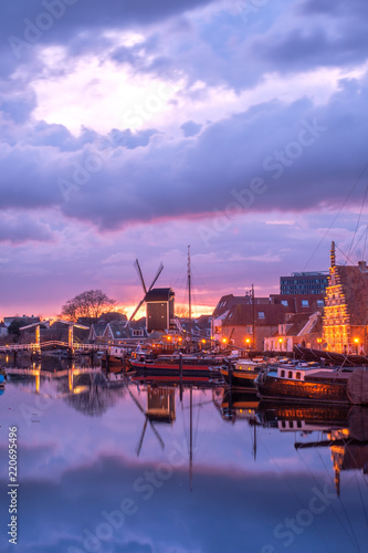 View of the canals of the city of Leiden with hoses, ships and boats at sunset. View of city channel with ships, the city of Leiden, Netherlands.