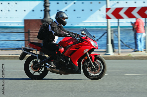 motorcyclist riding on a red motorcycle on the road