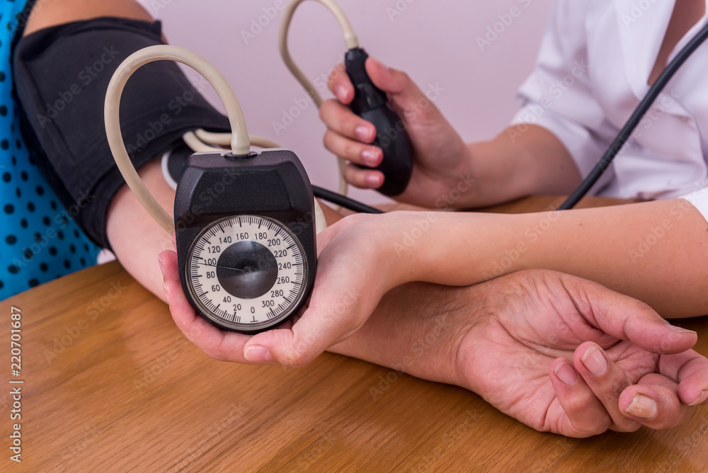 Female hands with tonometer measuring blood pressure