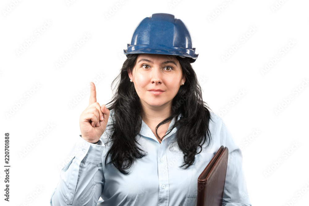 Young attractive brunette woman engineer or architect with blue safety hat showing pointer finger isolated on white background Young attractive brunette woman engineer or architect with blue safety hat showing pointer finger isolated on white background