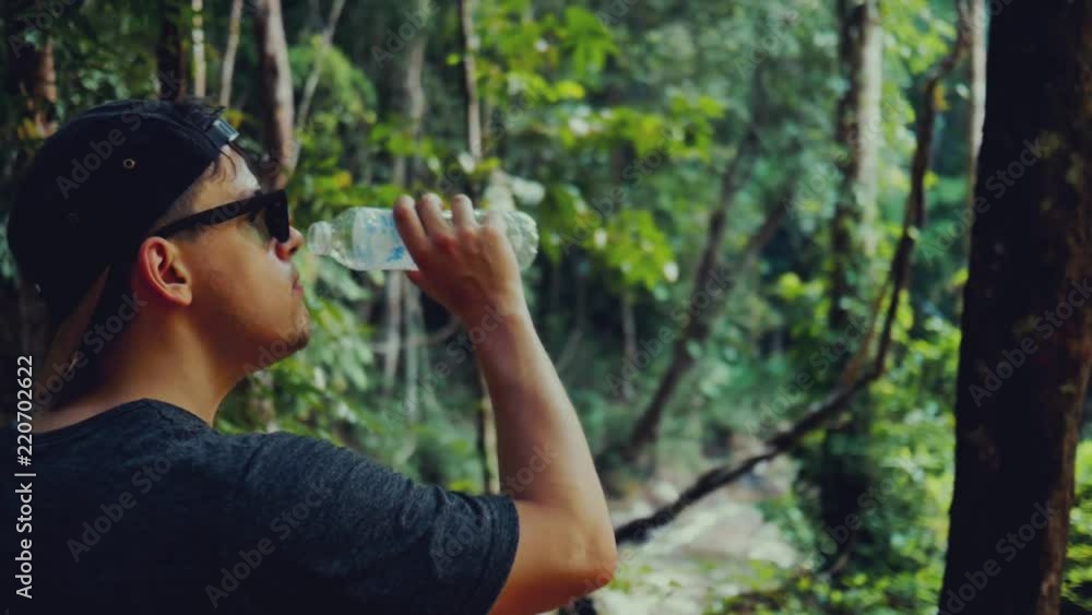 Man in the purchase of drinking water in a hot tropical forest Man in the purchase of drinking water in a hot tropical forest