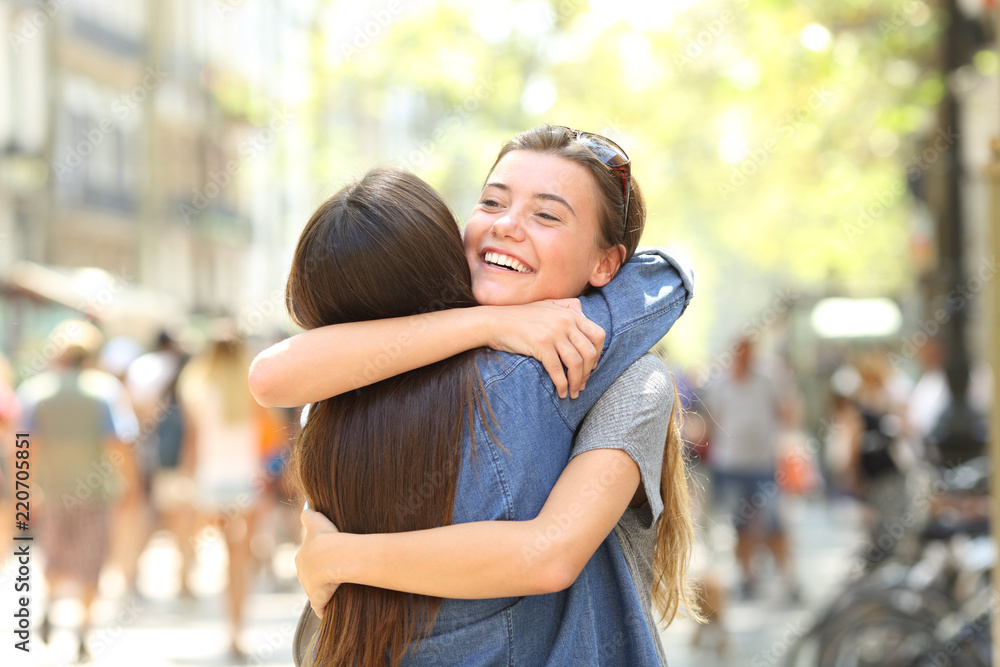 Friends meeting and cuddling in the street