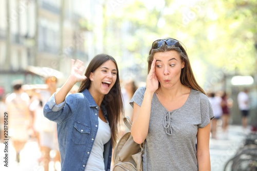 Teen greeting and friend ignoring her in the street