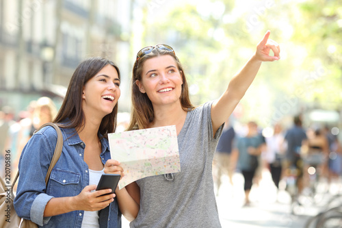 Tourists sightseeing holding a map and pointing up