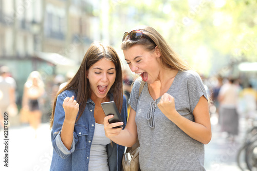Two excited winners watching online content