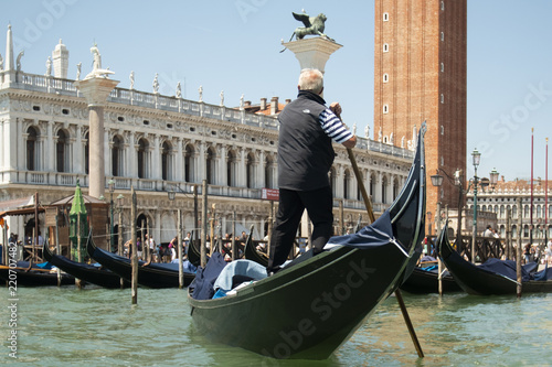 Venice, Italy - May 21, 2017: The gondola floats along the old narrow street in Venice. Gondola is the most attractive tourist transport in Venice.