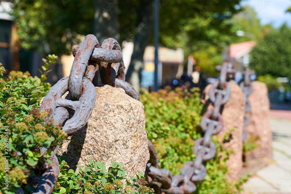 Old metal rusty chain on the street with blurred background. Old metal rusty chain on the street with blurred background.