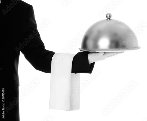 Waiter holding metal tray with lid on white background, closeup photo