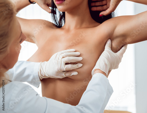 Fototapeta Doctor get examining breast of young woman
