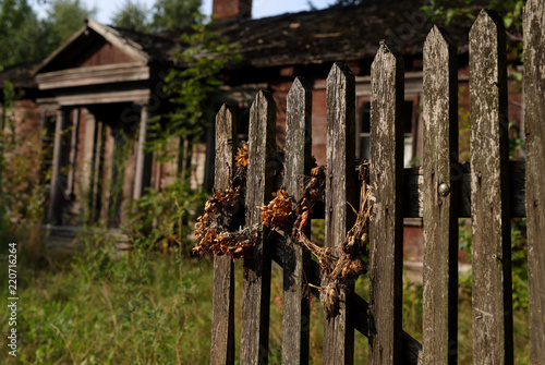 sign of the time old fence with dried flowers in the background of an old house