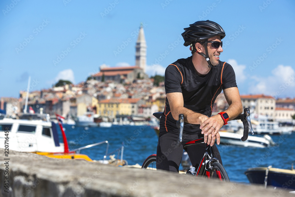 Fototapeta premium Kroatien, Istrien, Rovinj, Portrait Rennradfahrer bei Pause am Hafen