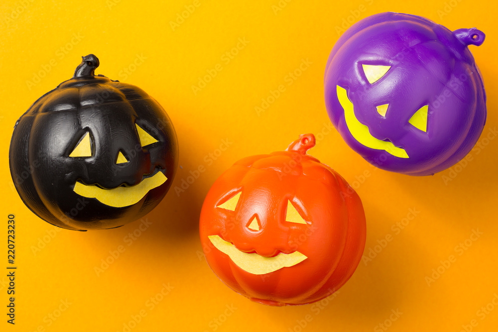 Halloween background concept. Top view of jack O pumpkin faces on orange table Halloween background concept. Top view of jack O pumpkin faces on orange table