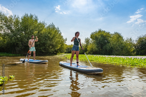 Man and woman stand up paddleboarding