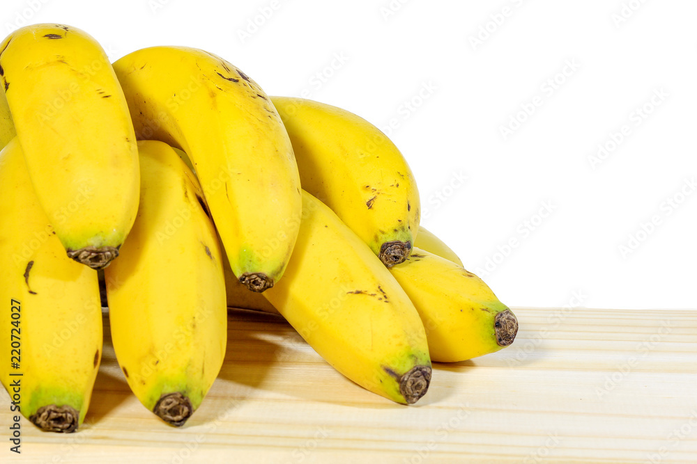 Bunch of bananas on wooden table, white background