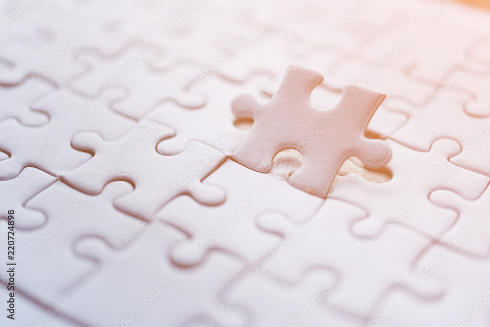 Fototapeta premium Jigsaw with one piece missing revealing orange background
