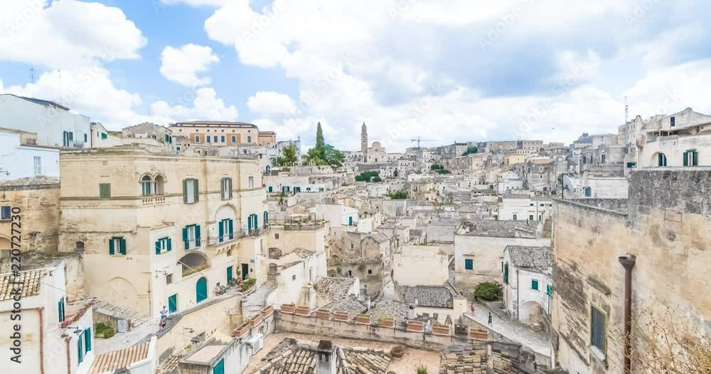 panoramic view of typical stones (Sassi di Matera) and church of Matera UNESCO European Capital of Culture 2019 under blue sky white clouds time lapse movement, Basilicata, Italy panoramic view of typical stones (Sassi di Matera) and church of Matera UNESCO European Capital of Culture 2019 under blue sky white clouds time lapse movement, Basilicata, Italy