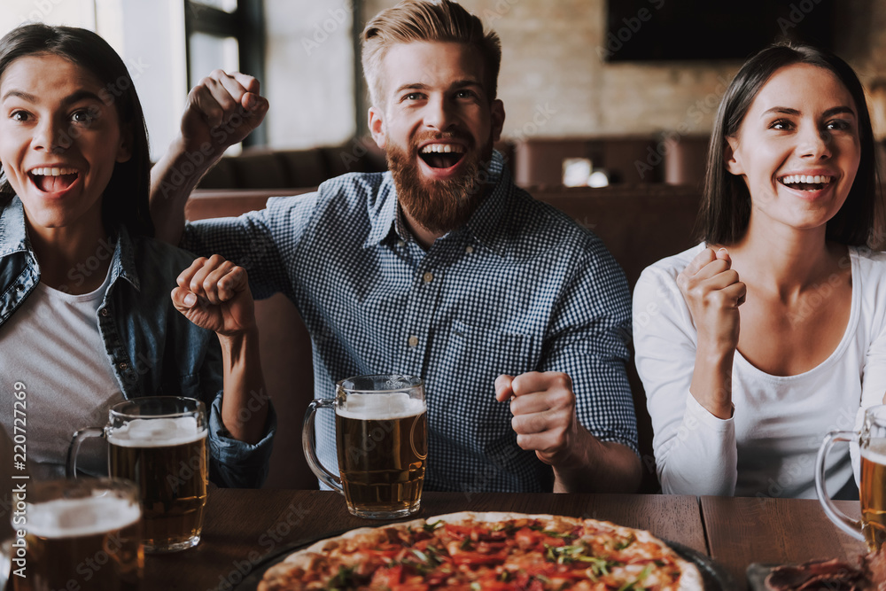 Handsome Smiling Friends Drinking Beer in Pub Handsome Smiling Friends Drinking Beer in Pub