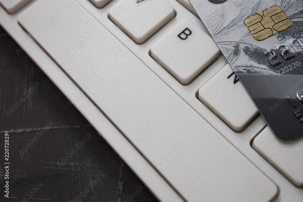 Close up credit card lie on white computer keyboard. Concept of internet purchase. Bank Credit Card on a Computer Keyboard Close up credit card lie on white computer keyboard. Concept of internet purchase. Bank Credit Card on a Computer Keyboard