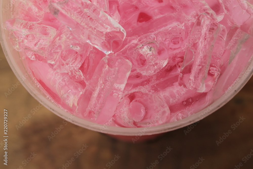 Closeup top view ice of strawberry sweet milk pink in takeaway cup.