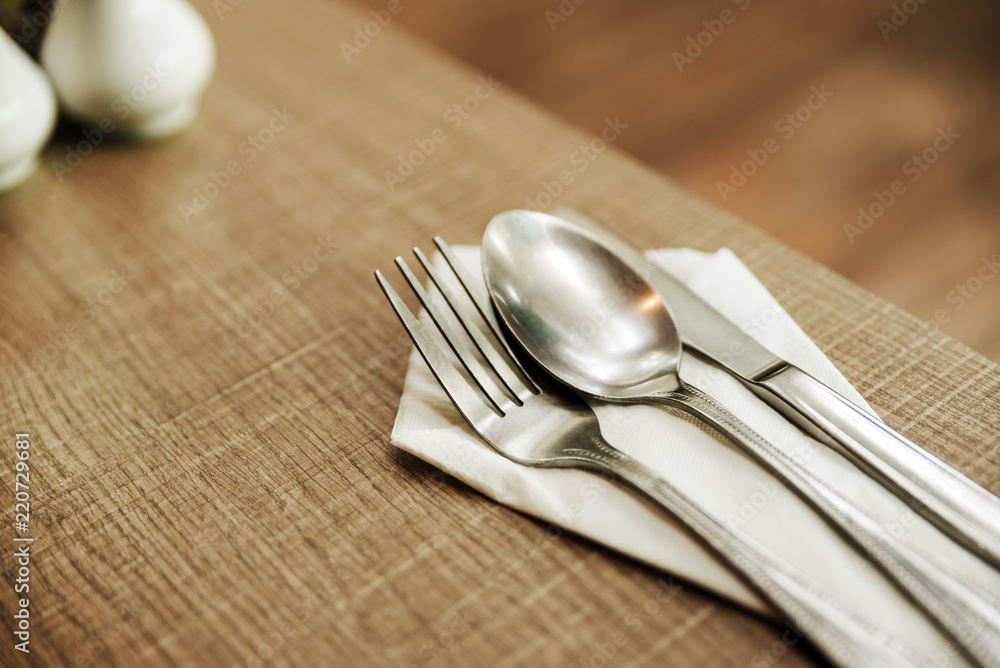 fork, spoon and knife with white paper on the old wood table For breakfast. fork, spoon and knife with white paper on the old wood table For breakfast.