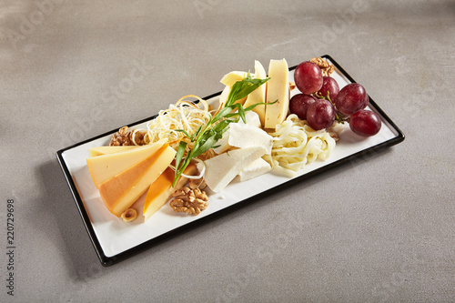 Wine Plate with Cheese Mix, Nuts and Grapes on White Rectangular Flat Plate photo