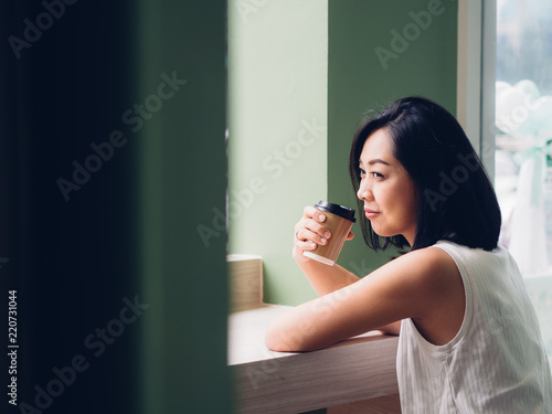 Woman is drinking hot cup of coffee in the cafe.