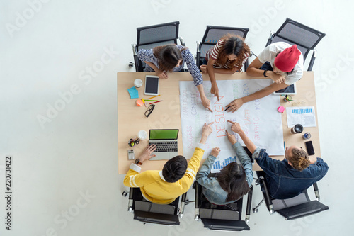 Top view scene of Asian and Multiethnic Business people with casual suit working with brainstorming and pointing to the design concept in the modern workplace, people business group concept