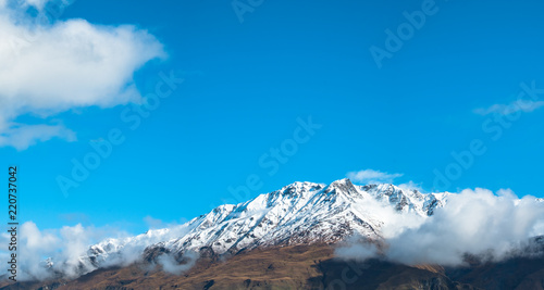 Panorama view. Stunning of the scenery of rocky mountain covered with snow after the raining day. Cloudy and foggy. Diamond lake track, Wanaka, New Zealand. photo