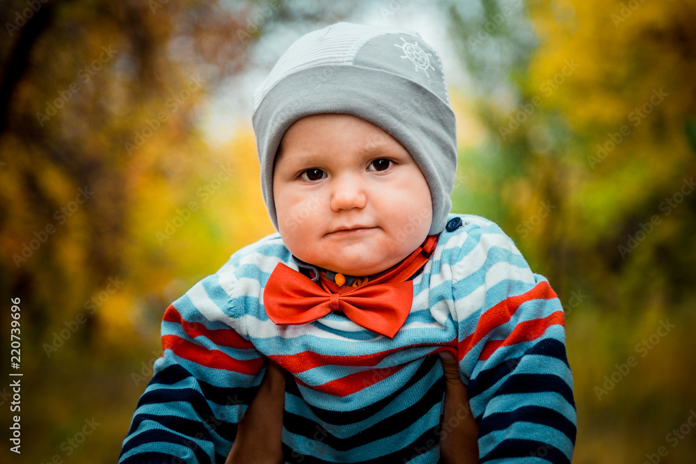 cute funny little kid with a red bow tie at the neck in autumn cute funny little kid with a red bow tie at the neck in autumn