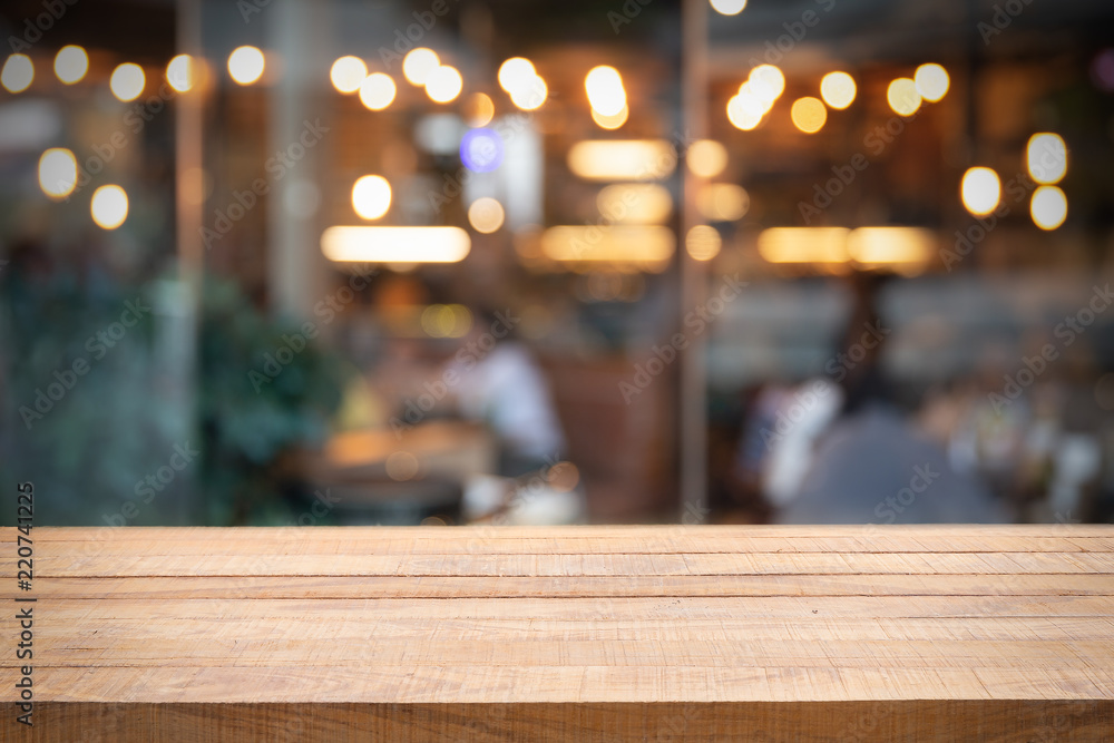 Empty wooden table and Photo of blurred restaurant or cafe.