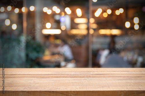 Empty wooden table and Photo of blurred restaurant or cafe.