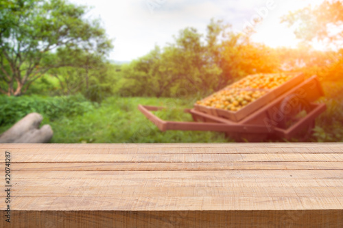 Wood table top with blur of orange garden in the morning.For montage product display.