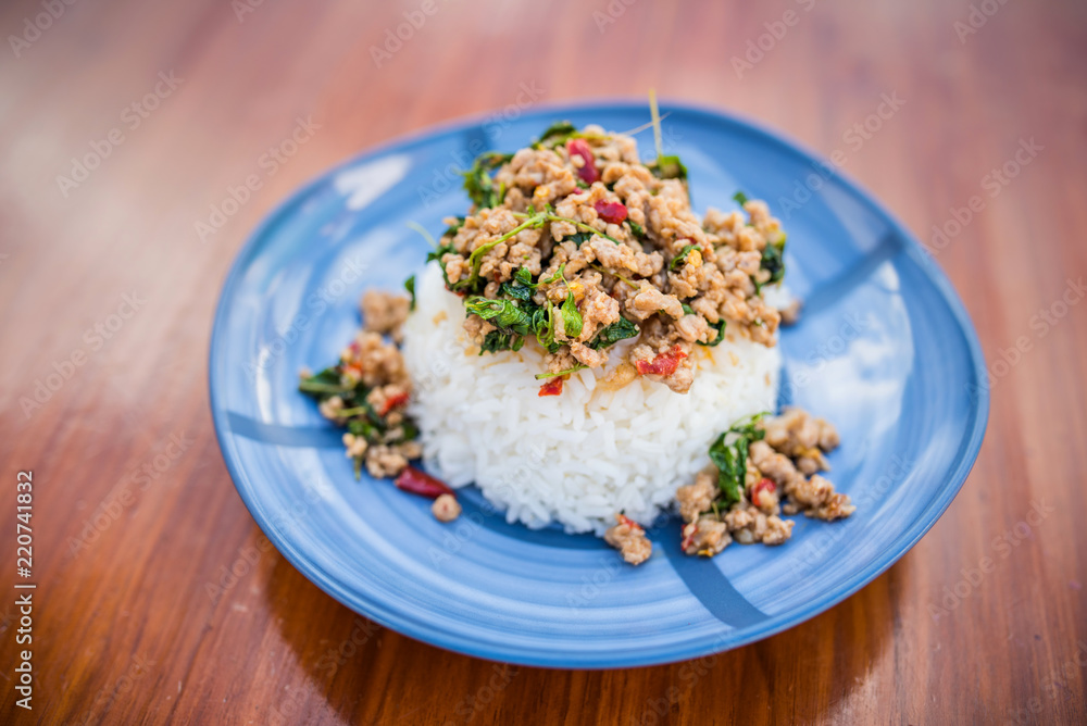 Thai food, Khao Kaprao Hmoo, pork fried with sweet brasil cover the steam rice Thai food, Khao Kaprao Hmoo, pork fried with sweet brasil cover the steam rice