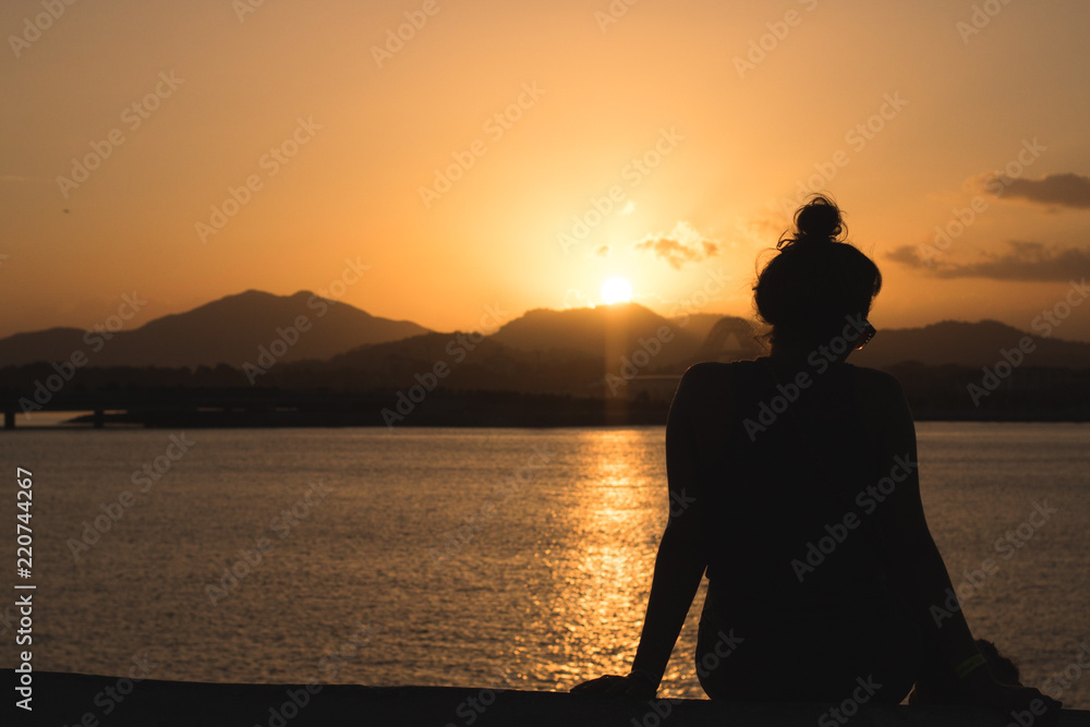 Woman sitting at sunset
