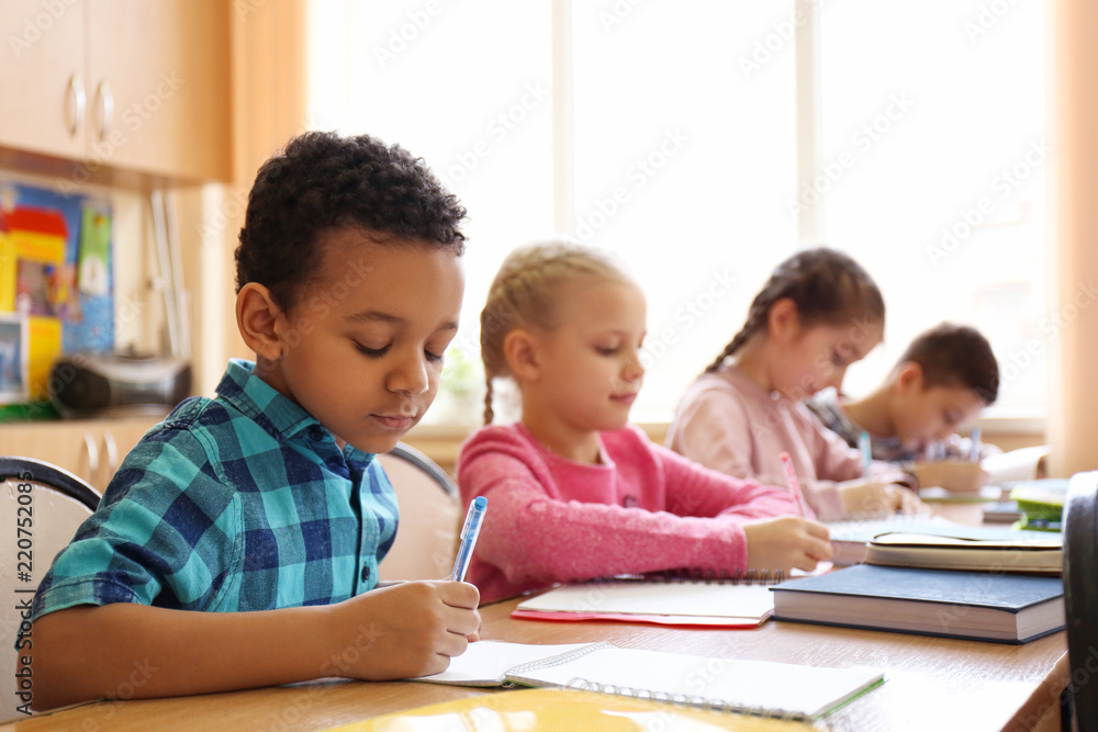 Cute children doing homework in classroom at school Cute children doing homework in classroom at school