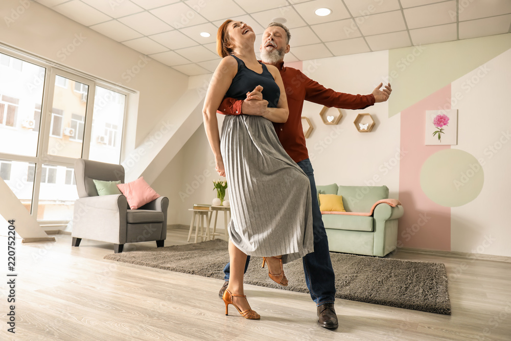 Happy mature couple dancing at home Happy mature couple dancing at home