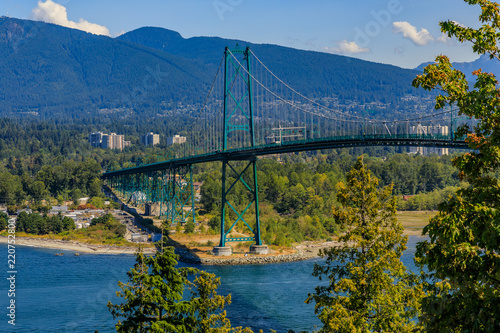 Lions Gate or First Narrows Bridge in Stanley Park Vancouver Canada with North Vancouver and mountains in the background photo