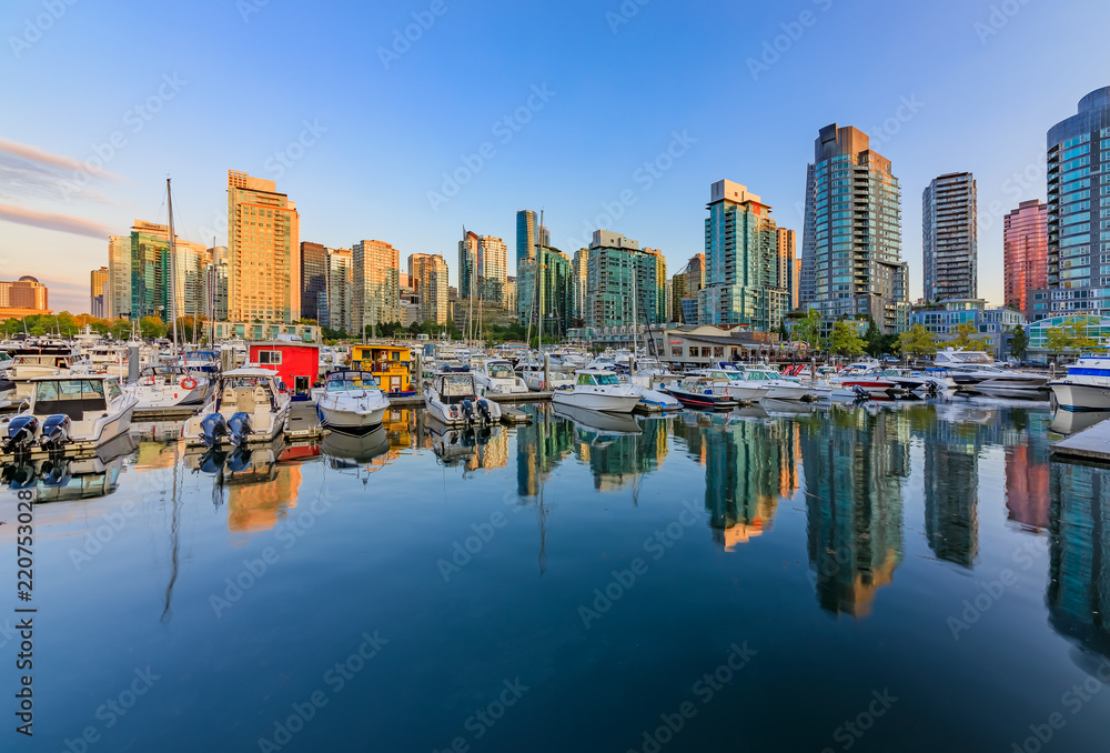 Naklejka premium Sunset at Coal Harbour in Vancouver British Columbia with downtown buildings boats and reflections in the water