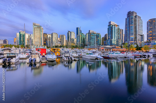 Sunset at Coal Harbour in Vancouver British Columbia with downtown buildings boats and reflections in the water